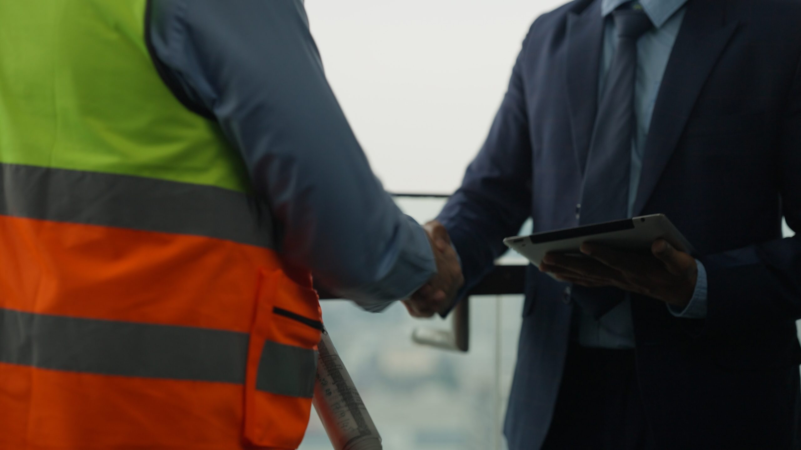 Construction worker shaking hands with a business person